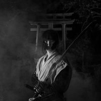 煙の中から現れた刀を持った侍、大和田稲荷神社の鳥居を背景にした時代劇の写真