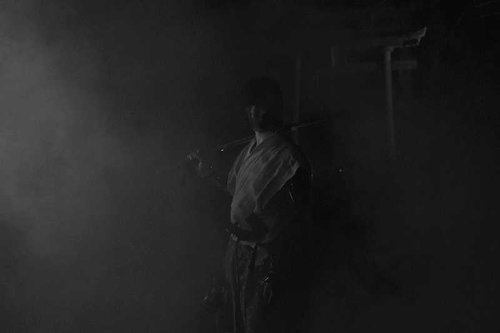 霧の中に刀を担ぐ侍と鳥居（モノクロ）