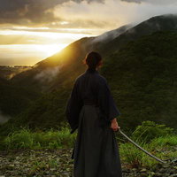 御霊櫃峠で夕日を眺める袴姿の侍の後ろ姿の写真