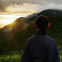御霊櫃峠から夕日を眺める袴姿の侍のシルエットの写真