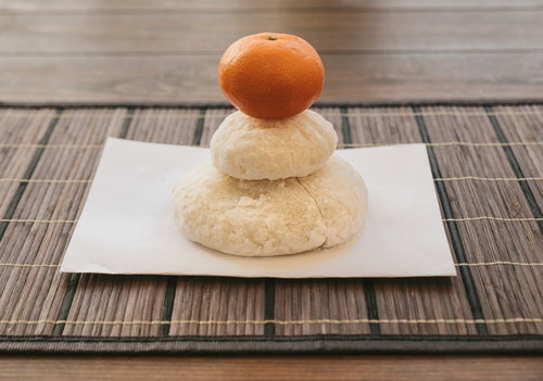 白い鏡餅の上にのせた橙色のみかんで構成した正月飾り