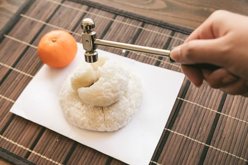 1月11日は鏡開きの日、ハンマーで鏡餅を割る