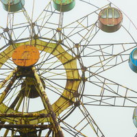 もう動かない観覧車の錆びついた鉄骨と色あせたゴンドラの写真