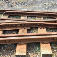 砂利の上に敷かれた錆びたトロッコレールと線路の写真