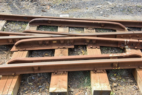 砂利の上に敷かれた錆びたトロッコレールと線路