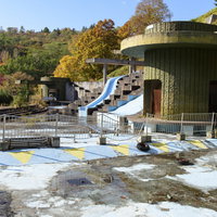 かつてはプールがあった廃墟とコンクリートの朽ちた構造物の写真