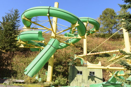 廃墟となったプール施設の折れたウォータースライダー