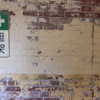 「担架」と書かれた古い廃墟の壁に記された緑色の十字マークの写真