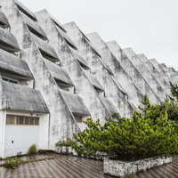 離島に建つ老朽化したコンクリート造りの無人ホテル（廃墟）の写真