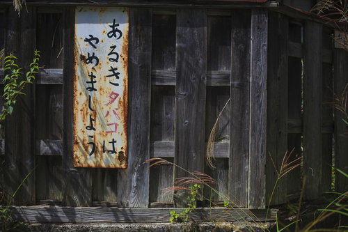 古い木造建物に設置された「あるきタバコはやめましょう」の注意看板