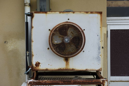 かなり古い室外機と錆びた外壁、劣化した建物の廃墟