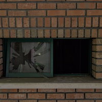 レンガの壁に割れたガラス窓の室内風景の写真