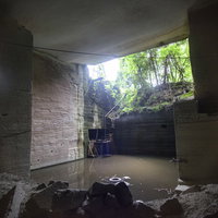 森の中に崩れる大谷石採掘場跡の土蔵の写真