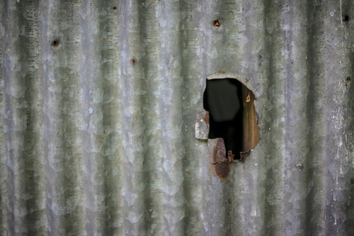 穴の空いたトタン壁面
