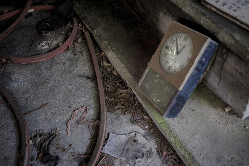 薄暗い廃墟に置き去られた古い時計の朽ちた風景