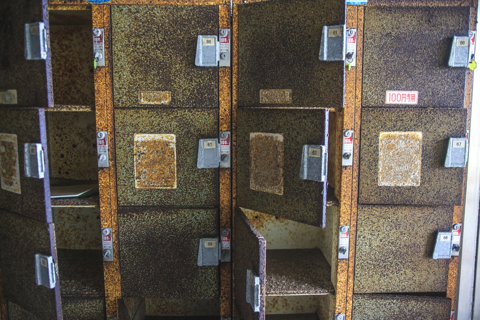 錆びて変色した100円コインロッカーが複数並んでいる廃墟の様子