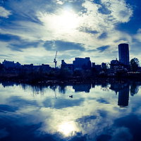 湖面に映る青空と街並みのビル群の写真