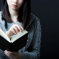 本を読む女性・ダーク背景の写真