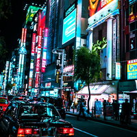 新橋の繁華街のネオンと路肩に停めるタクシーの写真