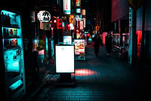 ネオンサインが光る飲み屋の看板と提灯が並ぶ裏路地