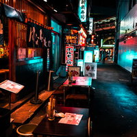 ネオンサインが光る路地裏の居酒屋街の夜景の写真