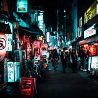 賑わう飲み屋街と行き交う人々、ネオンサインの灯る路地の写真