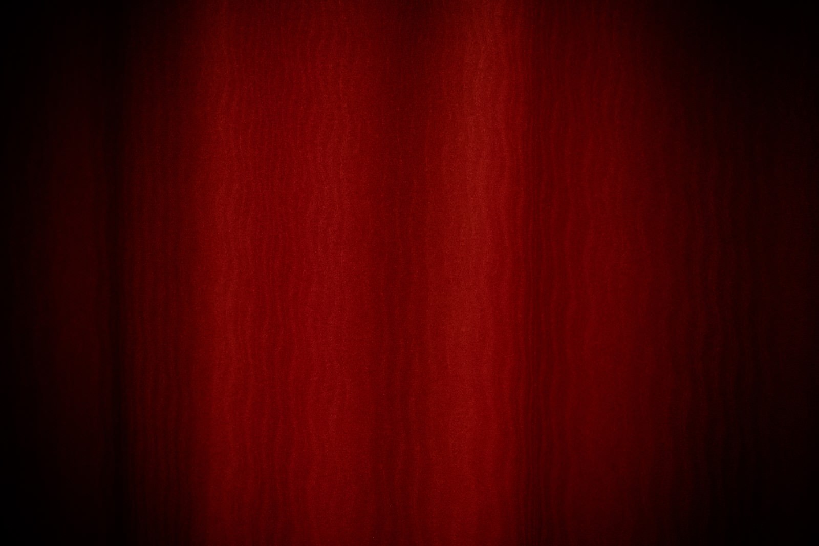 深い赤色から明るい赤色へのグラデーションが波状に流れるテクスチャ