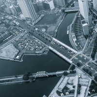 俯瞰で見た都会の街並みと川と橋の写真