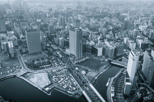 高い位置から霞がかった曇りの日に撮影した水辺沿いの高層ビルの都市風景