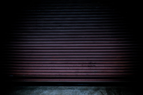 不気味で古びたシャッターの閉じた壁面、錆びた金属製