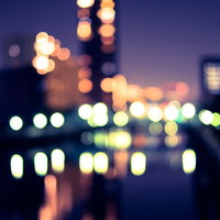 街灯とビルの窓灯がボケた夜景、紫紺の夜空に映える都市風景の写真