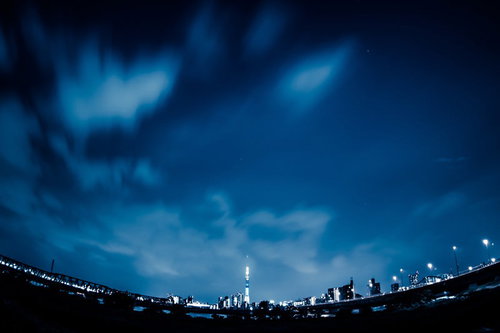 魚眼レンズで撮影した夜のスカイツリーと高層ビルの湾曲した夜景