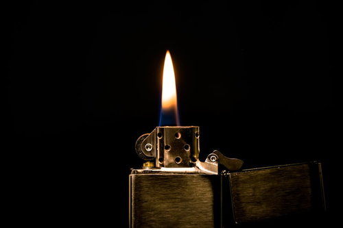 金色のオイルライターから立ち上がる橙色の炎