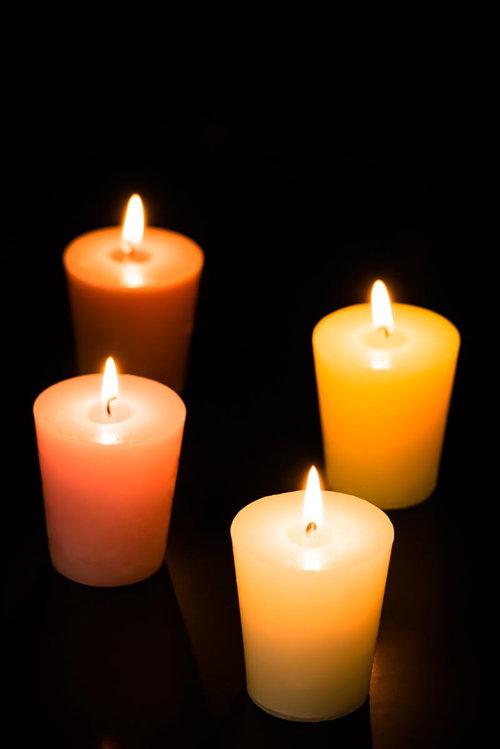 暗闇に灯るキャンドルとろうそく、オレンジ色の温かい炎