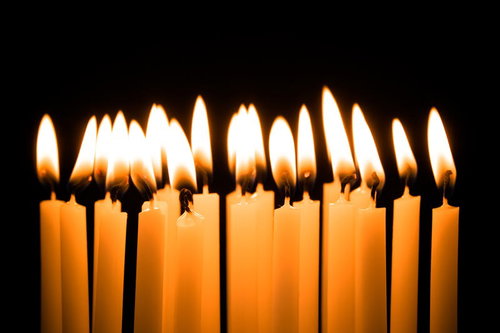 誕生日を彩る複数のろうそくの炎が灯る黒背景