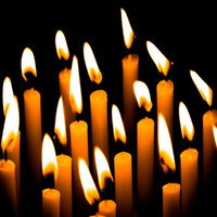 暗闇に並ぶ複数の和蝋燭の灯り、揺らめく炎と光の陰影の写真