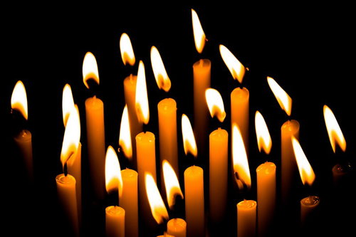 暗闇に並ぶ複数の和蝋燭の灯り、揺らめく炎と光の陰影