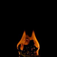 黒背景に映える赤とオレンジの炎が燃える紙くずの写真