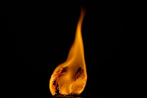 黒背景で炎に包まれた紙くずが激しく燃える炎上シーン