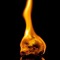 揺れる炎にともし火、黒背景に浮かぶオレンジ色の燃焼の写真