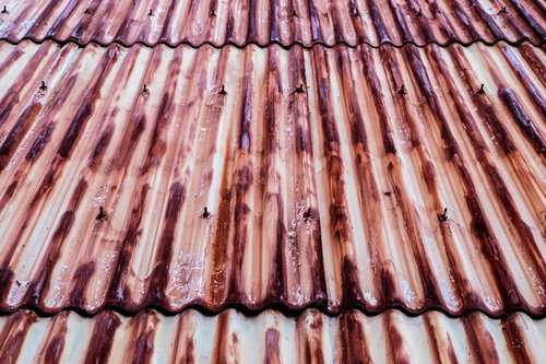 茶色く変色した錆びたトタン板の波状テクスチャー
