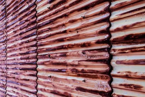 赤く錆びたトタン壁の劣化した金属表面テクスチャー