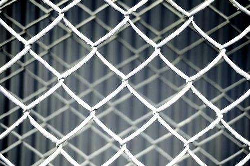 グレーの金網フェンスが重なった菱形テクスチャー