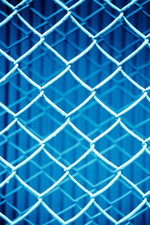 重なる青いフェンスの立体的なテクスチャー