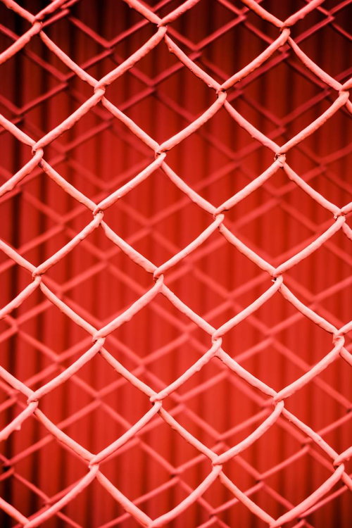 重なる赤いフェンスの菱形格子テクスチャー