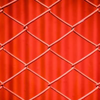 赤いネットフェンスの菱形網目パターンの写真