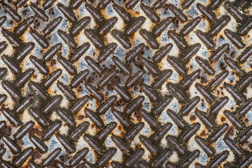 茶色と灰色に酸化した錆びたメタル製すべり止め足場の表面