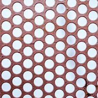 赤茶色の板に規則的に空いたドット穴のテクスチャーの写真