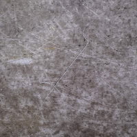 傷と汚れが目立つグレーのコンクリート壁のテクスチャーの写真