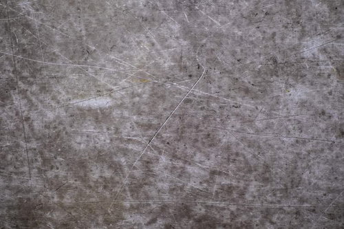 傷と汚れが目立つグレーのコンクリート壁のテクスチャー